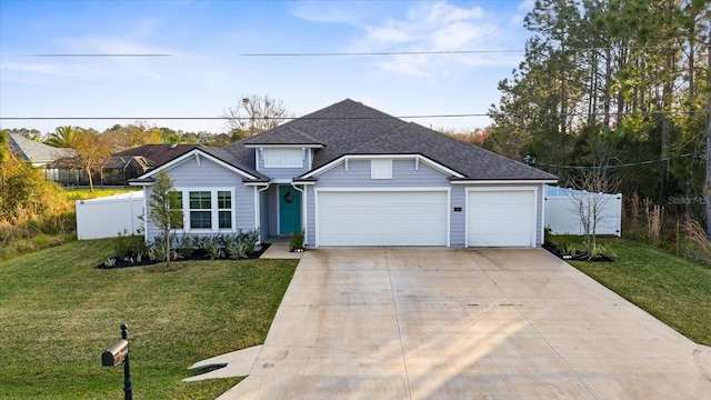 traditional-style home with concrete driveway, roof with shingles, an attached garage, fence, and a front yard