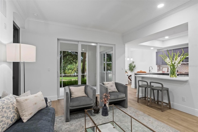 living area with light wood-style flooring, baseboards, crown molding, and recessed lighting