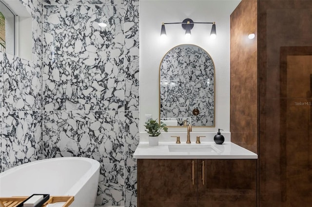 full bathroom with a freestanding bath, vanity, and tile walls