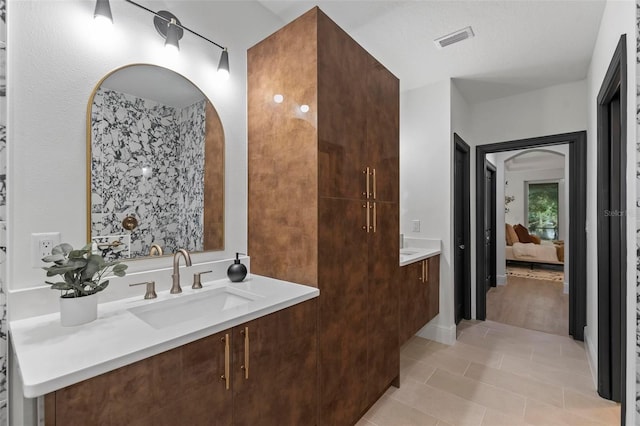 ensuite bathroom with ensuite bathroom, vanity, tile patterned flooring, and visible vents