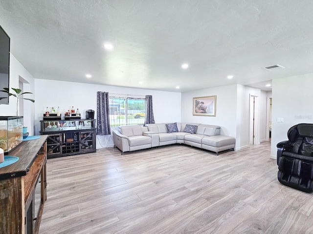 364 Palm Cir, Flagler Beach, FL 32136 - living room featuring a textured ceiling, recessed lighting, visible vents, light wood finished floors, and a bar