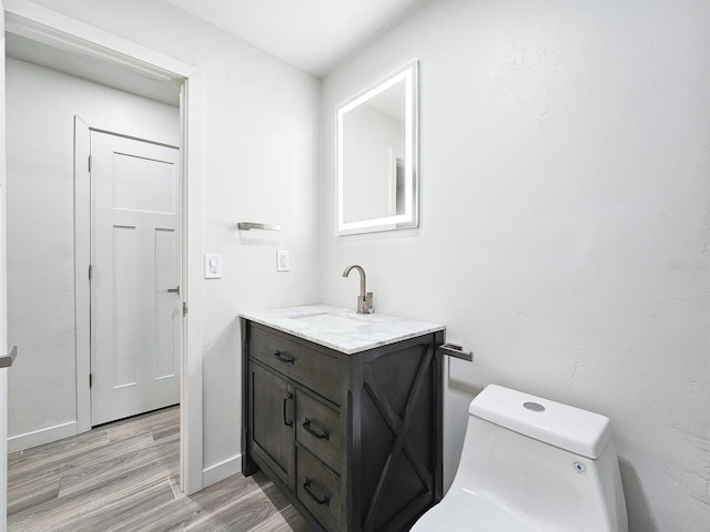 364 Palm Cir, Flagler Beach, FL 32136 - bathroom featuring baseboards, vanity, toilet, and wood finished floors