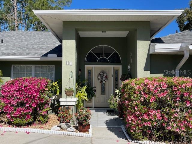 33 Poinsettia Ln, Palm Coast, FL 32164 - view of exterior entry featuring stucco siding and roof with shingles