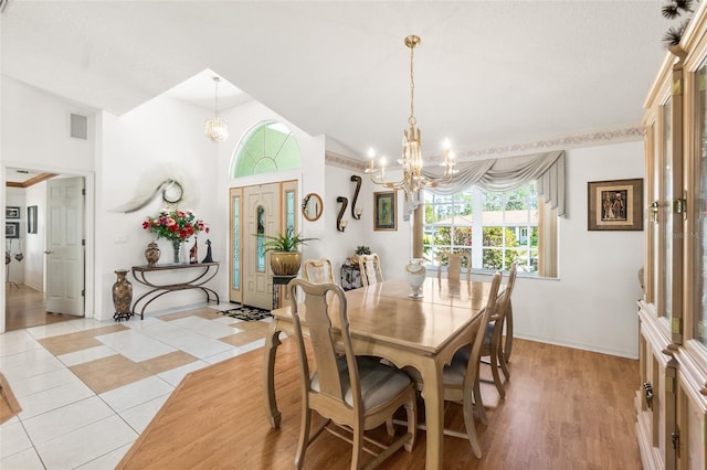 33 Poinsettia Ln, Palm Coast, FL 32164 - dining room featuring a chandelier, lofted ceiling, and light tile patterned flooring
