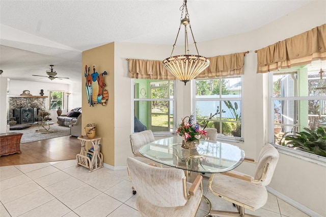 33 Poinsettia Ln, Palm Coast, FL 32164 - dining room with light tile patterned floors, a ceiling fan, and a stone fireplace