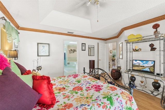 33 Poinsettia Ln, Palm Coast, FL 32164 - bedroom featuring wood finished floors, ornamental molding, ensuite bathroom, ceiling fan, and a raised ceiling