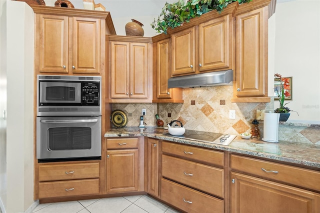 33 Poinsettia Ln, Palm Coast, FL 32164 - kitchen with stainless steel appliances, light stone counters, under cabinet range hood, tasteful backsplash, and light tile patterned flooring