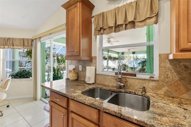 33 Poinsettia Ln, Palm Coast, FL 32164 - kitchen featuring lofted ceiling, brown cabinetry, plenty of natural light, and decorative backsplash