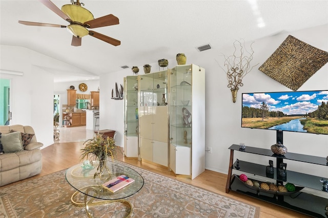 33 Poinsettia Ln, Palm Coast, FL 32164 - living area featuring light wood finished floors, vaulted ceiling, and ceiling fan