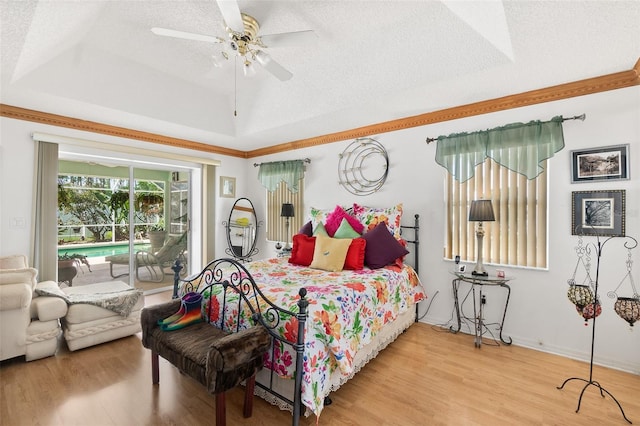 33 Poinsettia Ln, Palm Coast, FL 32164 - bedroom with a textured ceiling, wood finished floors, a raised ceiling, access to exterior, and a ceiling fan
