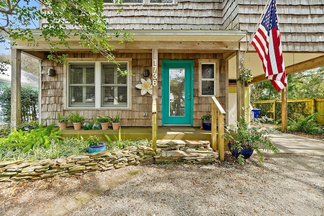 doorway to property featuring driveway and fence