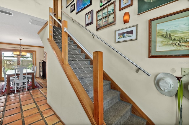 stairway featuring tile patterned flooring, visible vents, crown molding, and baseboards