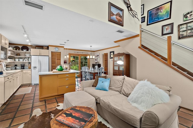 tiled living area with stairs, visible vents, a sink, and ornamental molding