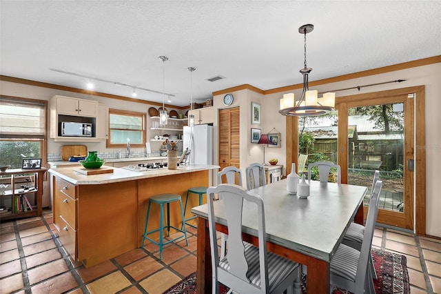 kitchen featuring light countertops, white appliances, visible vents, and a healthy amount of sunlight