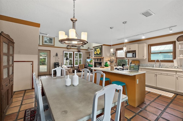 dining area with a chandelier, visible vents, a fireplace, and light tile patterned floors