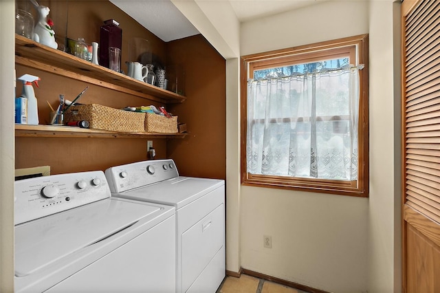 clothes washing area with laundry area, baseboards, washing machine and clothes dryer, and light tile patterned floors