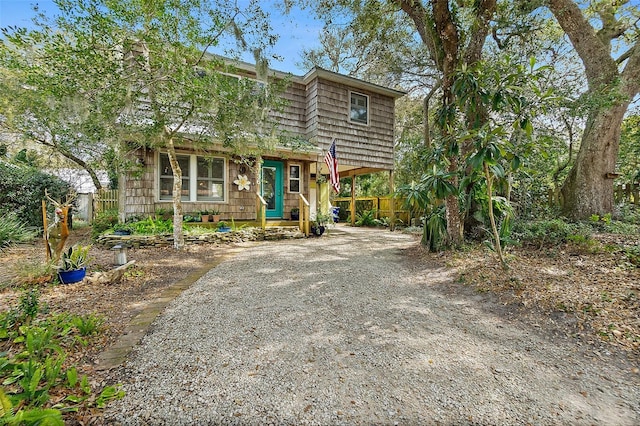 view of front of property with gravel driveway and fence