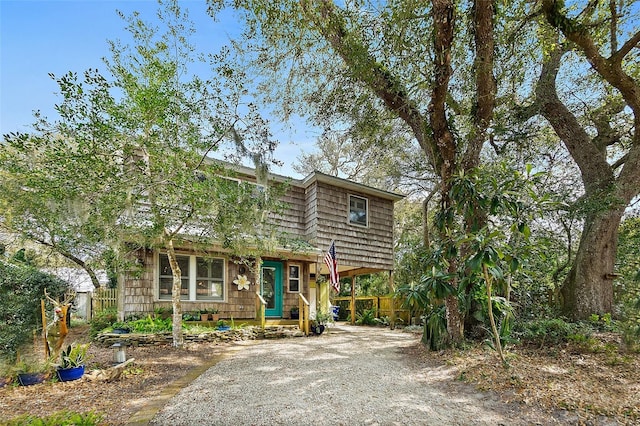 view of front facade featuring driveway and fence