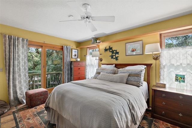 bedroom with access to exterior, multiple windows, and a ceiling fan