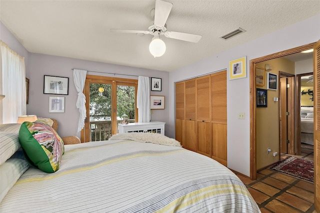 bedroom featuring a textured ceiling, a closet, visible vents, and a ceiling fan