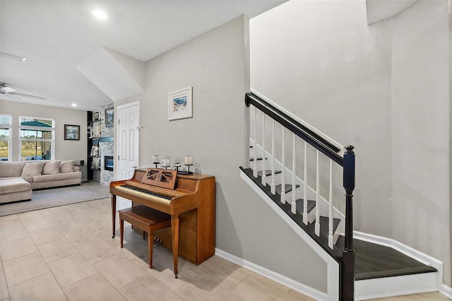 stairs featuring baseboards, a ceiling fan, tile patterned flooring, a fireplace, and recessed lighting