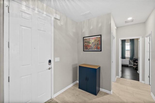 foyer entrance with baseboards, visible vents, and wood tiled floor