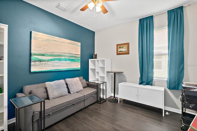 living area featuring ceiling fan, dark wood-type flooring, visible vents, and baseboards