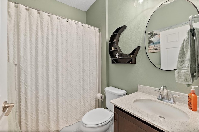 bathroom with a textured wall, curtained shower, vanity, and toilet