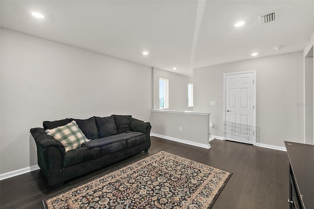 living room featuring dark wood-style flooring, recessed lighting, visible vents, and baseboards