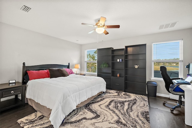 bedroom with baseboards, visible vents, dark wood finished floors, and a ceiling fan