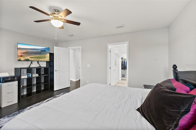 bedroom with ceiling fan, visible vents, connected bathroom, and wood finished floors