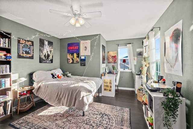 bedroom with ceiling fan, wood finished floors, and baseboards