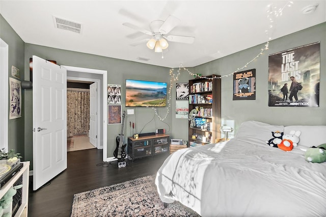 bedroom with ceiling fan, wood finished floors, visible vents, and baseboards