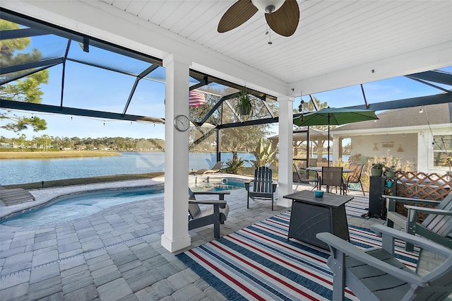 view of patio / terrace featuring a hot tub, an outdoor pool, a ceiling fan, a lanai, and a water view