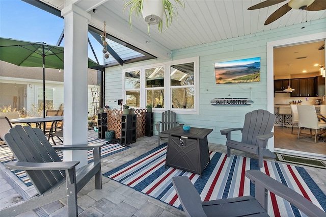 sunroom featuring ceiling fan and beam ceiling