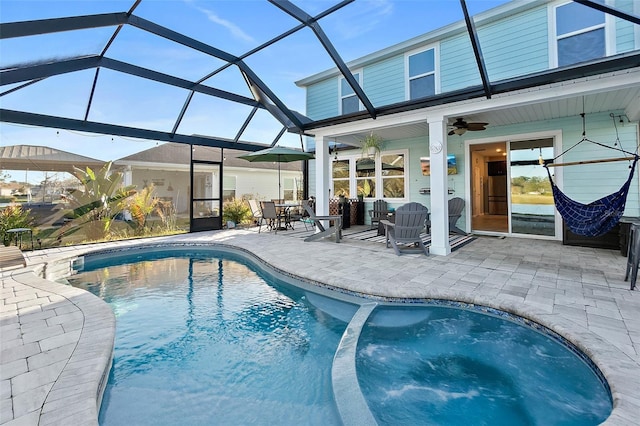 view of pool featuring a ceiling fan, a pool with connected hot tub, a patio, and a lanai