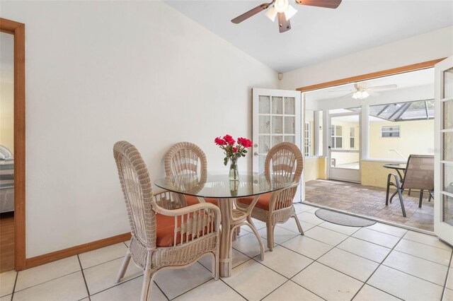 dining room featuring vaulted ceiling, light tile patterned flooring, a ceiling fan, and baseboards