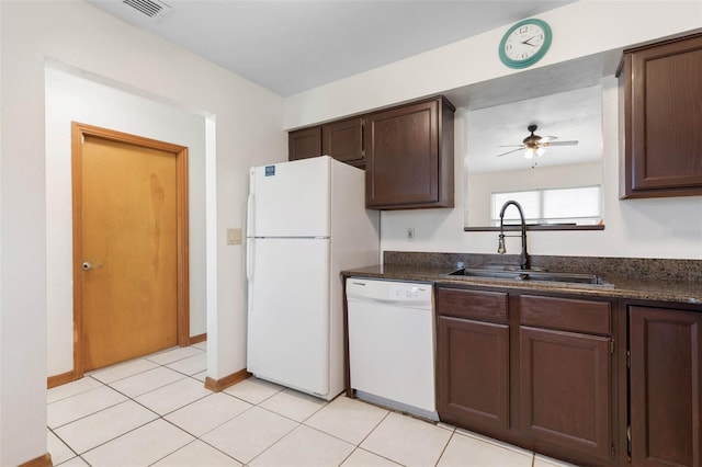 kitchen with dark brown cabinetry, white appliances, light tile patterned floors, visible vents, and a sink