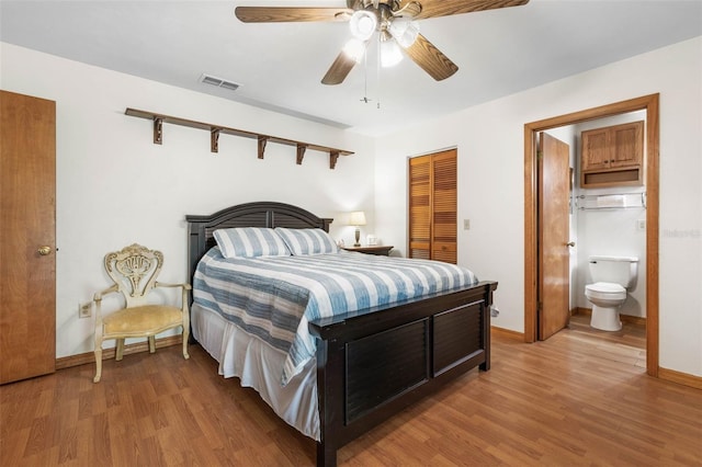 bedroom with light wood finished floors, baseboards, visible vents, and a closet