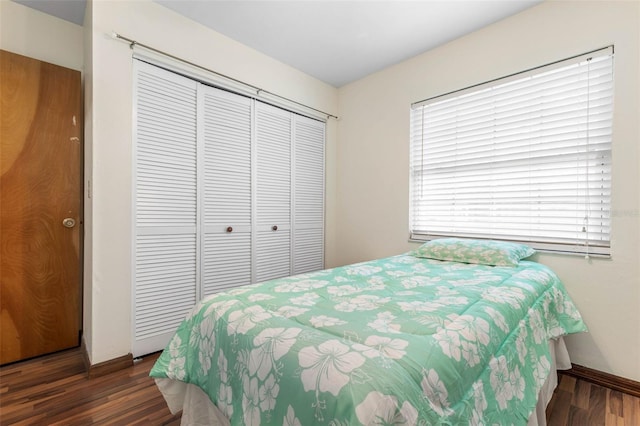 bedroom with a closet, baseboards, and wood finished floors