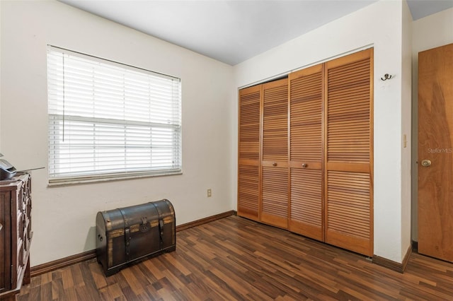 bedroom featuring a closet, wood finished floors, and baseboards