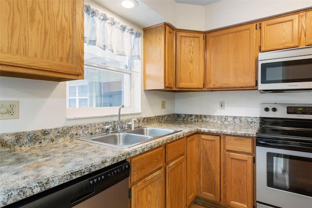 kitchen featuring stainless steel appliances, brown cabinetry, and a sink