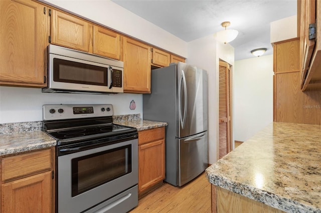 kitchen featuring light wood-type flooring, appliances with stainless steel finishes, and light countertops