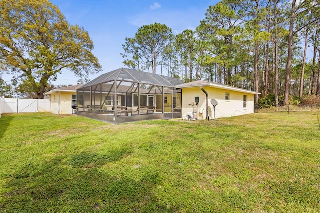 rear view of house featuring a yard, stucco siding, a fenced backyard, and a lanai