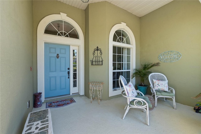 property entrance featuring a porch and stucco siding