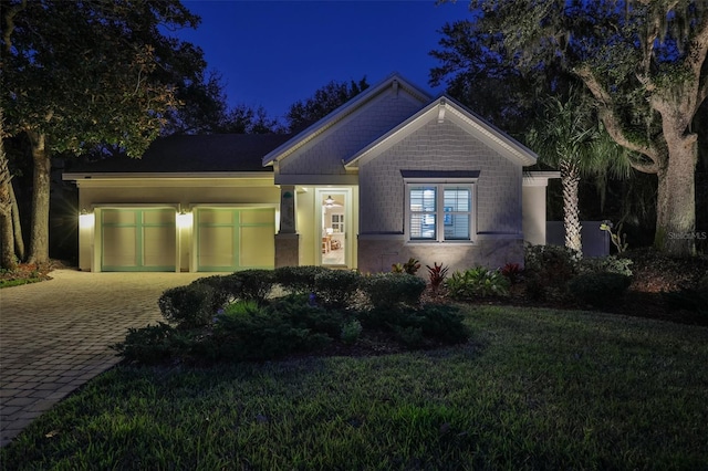 craftsman-style house featuring decorative driveway and a yard