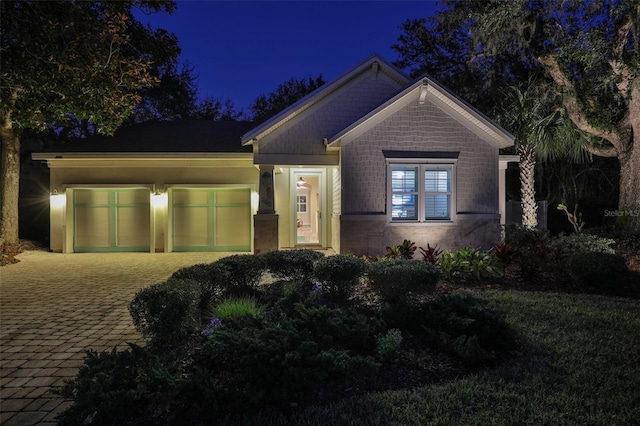 craftsman-style home featuring decorative driveway and a garage