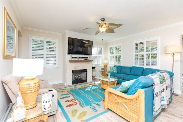 living area with a healthy amount of sunlight, ornamental molding, and wood finished floors