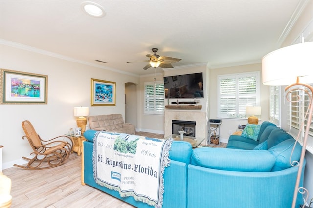 living room with crown molding, wood finished floors, and a wealth of natural light