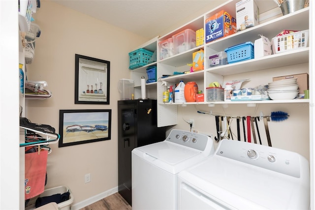 laundry room with laundry area, wood finished floors, baseboards, and washer and clothes dryer